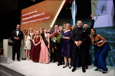 Christbaumdorf Mittelsinn e. V. gewinnt den Taspo Award 2024 für Beste Marketingaktivität analog in Berlin Das Team des Christbaumdorf Mittelsinn e. V. feiert auf der Bühne den Gewinn des Taspo Award 2024 in der Kategorie Beste Marketingaktivität analog in Berlin
